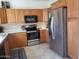 Kitchen boasts wood cabinets, stainless steel appliances, and tile floor at 17449 N Fairway Dr, Surprise, AZ 85374