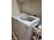 Functional laundry room with washer, dryer, and storage at 17449 N Fairway Dr, Surprise, AZ 85374