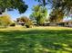 View of a community's grassy backyard with mature trees and homes at 19002 N Signal Butte Cir, Sun City, AZ 85373