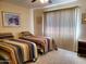 Bright bedroom with two twin beds and window at 19002 N Signal Butte Cir, Sun City, AZ 85373