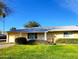 Ranch style home with well-manicured lawn and attached garage at 19002 N Signal Butte Cir, Sun City, AZ 85373