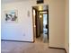 View of a hallway with carpet, leading to a bathroom and another room at 19002 N Signal Butte Cir, Sun City, AZ 85373