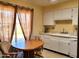 Eat-in kitchen with white cabinets, dishwasher, and a view of the backyard at 19002 N Signal Butte Cir, Sun City, AZ 85373