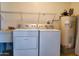 Laundry room with washer, dryer, sink, and hot water heater at 19002 N Signal Butte Cir, Sun City, AZ 85373