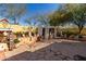 Spacious backyard with stone pavers, mature trees, and a unique decorative pergola at 19308 W Jefferson St, Buckeye, AZ 85326