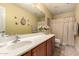 Well-lit bathroom featuring butterfly accents, a large vanity mirror, and a patterned shower curtain at 19308 W Jefferson St, Buckeye, AZ 85326