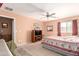 Bedroom showcases a ceiling fan, window with curtains, neutral walls and carpet, and a king bed at 19308 W Jefferson St, Buckeye, AZ 85326