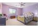 Bedroom with light purple walls, ceiling fan, and floral bedding at 19308 W Jefferson St, Buckeye, AZ 85326