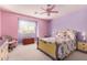 Pink and purple bedroom with floral bedding, ceiling fan, and window with soft light at 19308 W Jefferson St, Buckeye, AZ 85326