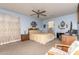 Spacious bedroom with pale blue walls featuring a ceiling fan and a bed with floral curtains and detailed decor at 19308 W Jefferson St, Buckeye, AZ 85326