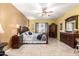 Spacious bedroom with tiled floor, ceiling fan, and dark wood furniture at 19308 W Jefferson St, Buckeye, AZ 85326