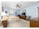 Bedroom with blue walls, ceiling fan, carpet, and beige bedding at 19308 W Jefferson St, Buckeye, AZ 85326