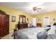 Bedroom featuring wood cabinet, dresser with mirror, ceiling fan, and carpet at 19308 W Jefferson St, Buckeye, AZ 85326