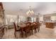 A spacious dining room with a long wooden table set for eight, complemented by soft lighting and tile flooring at 19308 W Jefferson St, Buckeye, AZ 85326