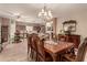 Spacious dining area with tiled floors, chandelier, and an open-concept kitchen in the background at 19308 W Jefferson St, Buckeye, AZ 85326