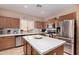 Well-appointed kitchen featuring a central island with tiled countertop, stainless appliances, and ample cabinet space at 19308 W Jefferson St, Buckeye, AZ 85326