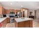 Modern kitchen with stainless steel appliances, light wood cabinetry, and a functional island for meal preparation and serving at 19308 W Jefferson St, Buckeye, AZ 85326