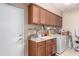 Laundry room with wooden cabinets, a sink with counter, and a washing machine at 19308 W Jefferson St, Buckeye, AZ 85326