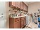 Functional laundry room with cabinets, open shelving, a sink, and a modern washer and dryer at 19308 W Jefferson St, Buckeye, AZ 85326