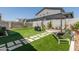 Backyard with artificial grass, seating, and a pergola with paved area at 19756 W Roma Ave, Litchfield Park, AZ 85340