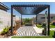 Pergola covered patio area with plants and decorative features in the backyard at 19756 W Roma Ave, Litchfield Park, AZ 85340
