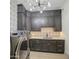 Modern laundry room with dark cabinetry, patterned backsplash, and updated washer and dryer at 20628 E Natalie Way, Queen Creek, AZ 85142