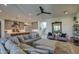 Open living room with gray sectional sofa, large mirror, and view of kitchen at 20628 E Natalie Way, Queen Creek, AZ 85142