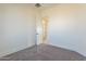 Bright bedroom with carpeted floor, neutral walls, and a door to hallway at 2383 E Cana Ln, Casa Grande, AZ 85194