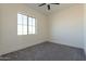 Bedroom with large window, ceiling fan, and neutral decor at 2383 E Cana Ln, Casa Grande, AZ 85194