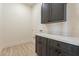 Laundry room with dark cabinets, quartz countertop, and tile floor at 2383 E Cana Ln, Casa Grande, AZ 85194