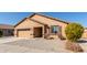 Tan house with a two-car garage and a landscaped yard at 25360 W Fremont Ct, Buckeye, AZ 85326