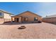 Tan house exterior with covered patio and gravel yard at 25360 W Fremont Ct, Buckeye, AZ 85326