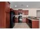 Well-equipped kitchen with dark wood cabinets and granite countertops at 25360 W Fremont Ct, Buckeye, AZ 85326