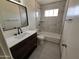 Clean bathroom with dark vanity, white countertop, and bathtub at 2611 N 40Th Ave, Phoenix, AZ 85009