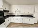 White kitchen with black countertops and gas stove at 2611 N 40Th Ave, Phoenix, AZ 85009