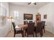 Dining room with dark wood table, six chairs, and southwestern decor at 26236 W Wahalla Ln, Buckeye, AZ 85396