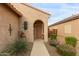 Front entry with walkway, arched doorway, and desert landscaping at 26236 W Wahalla Ln, Buckeye, AZ 85396