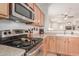 Kitchen with stainless steel stovetop, microwave and wood cabinets at 26236 W Wahalla Ln, Buckeye, AZ 85396