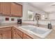 Kitchen features a double sink, light countertops, and wood cabinets at 26236 W Wahalla Ln, Buckeye, AZ 85396