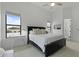 Bedroom with a sleek black bed frame, bright natural light, and adjacent bathroom at 2916 E Arrowhead Trl, Gilbert, AZ 85297