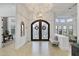 A large, ornate iron door opens into a bright foyer featuring hardwood floors and a decorative chandelier at 2916 E Arrowhead Trl, Gilbert, AZ 85297