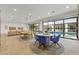 Bright recreation room with dining area and ping pong table, featuring a glass garage door overlooking the pool at 2916 E Arrowhead Trl, Gilbert, AZ 85297