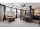 Elegant main bedroom featuring a four-poster bed, tray ceiling, and large windows at 3115 E Turnberry Dr, Gilbert, AZ 85298