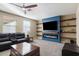 Comfortable living room featuring a modern fireplace, built-in shelves, and a ceiling fan at 3115 E Turnberry Dr, Gilbert, AZ 85298