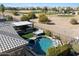 Aerial view of a backyard with a pool, hot tub, outdoor kitchen, putting green, and golf course view at 3374 E Virgil Dr, Gilbert, AZ 85298