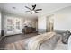 Spacious main bedroom boasts a ceiling fan and french doors, rug and neutral paint at 3374 E Virgil Dr, Gilbert, AZ 85298