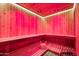 Indoor sauna with wooden benches and red mood lighting at 3374 E Virgil Dr, Gilbert, AZ 85298