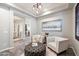 Sitting area with decoratively lit ceiling, artwork, chairs and a tufted ottoman at 3374 E Virgil Dr, Gilbert, AZ 85298