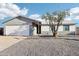 Single story home with a white exterior, two-car garage, and gravel driveway at 3410 E Everett Dr, Phoenix, AZ 85032