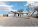 Ranch style home with a white exterior, two-car garage, and a gravel driveway at 3410 E Everett Dr, Phoenix, AZ 85032